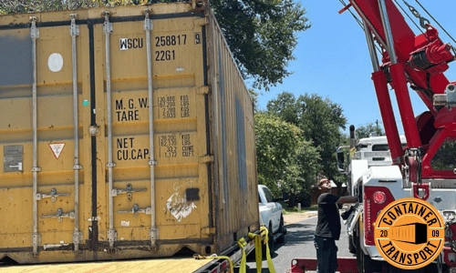 Crane lifting a container on a trailer.
