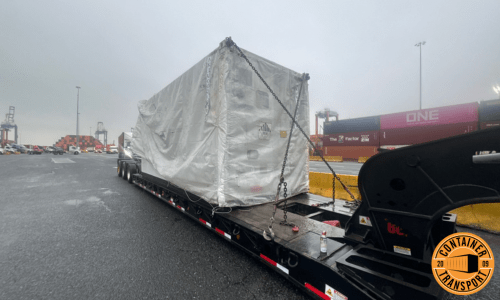 Container wrapped on a RGN trailer for transport.