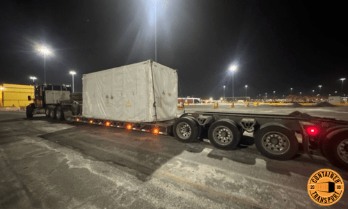 Wrapped Container strapped onto a RGN trailer for transport.