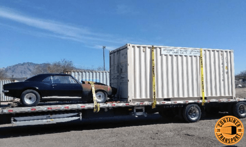 Container strapped onto a Flatbed trailer for transport.