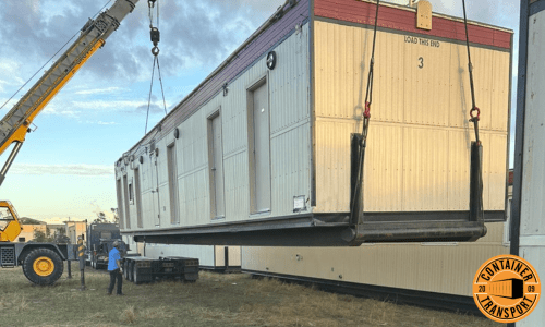 Crane loading container onto a trailer for transport.