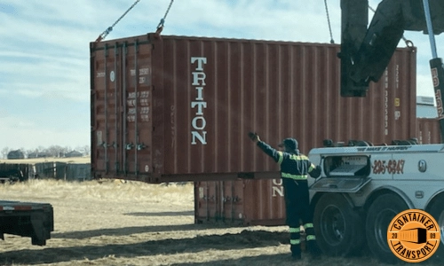 Crane loading a container on a trailer for transport.