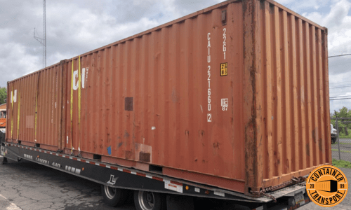 Container strapped onto a trailer for transport.