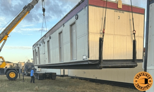 Crane loading container onto a trailer for transport.