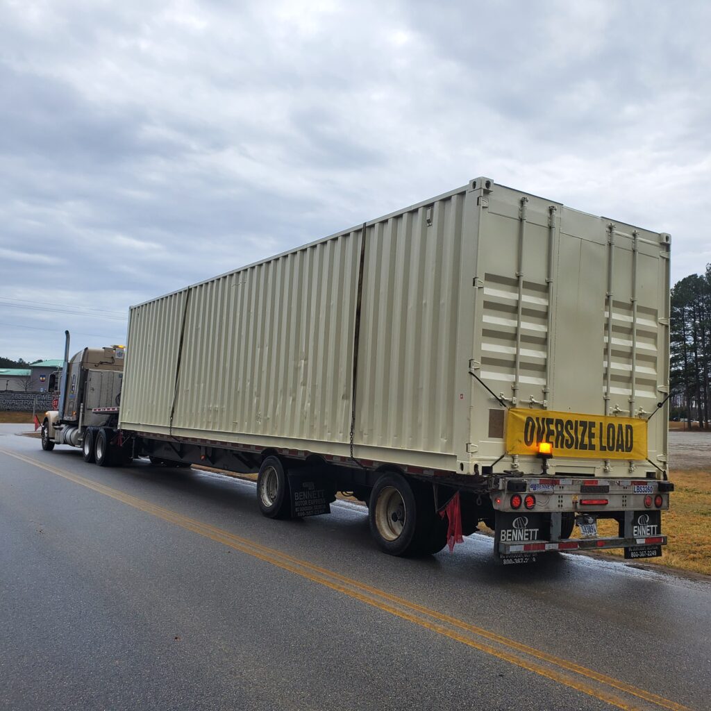 Transporting an oversize container while adhering to top shipping container transport regulations.