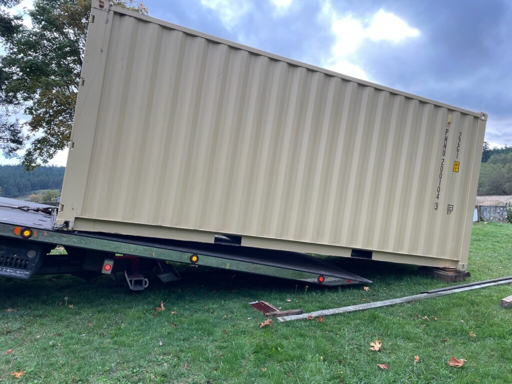 Off loading a container from a tilt trailer.