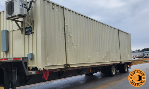 White container with AC unit being transported.