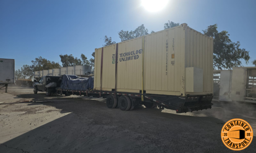 Container Strapped on a flatbed trailer for transport.